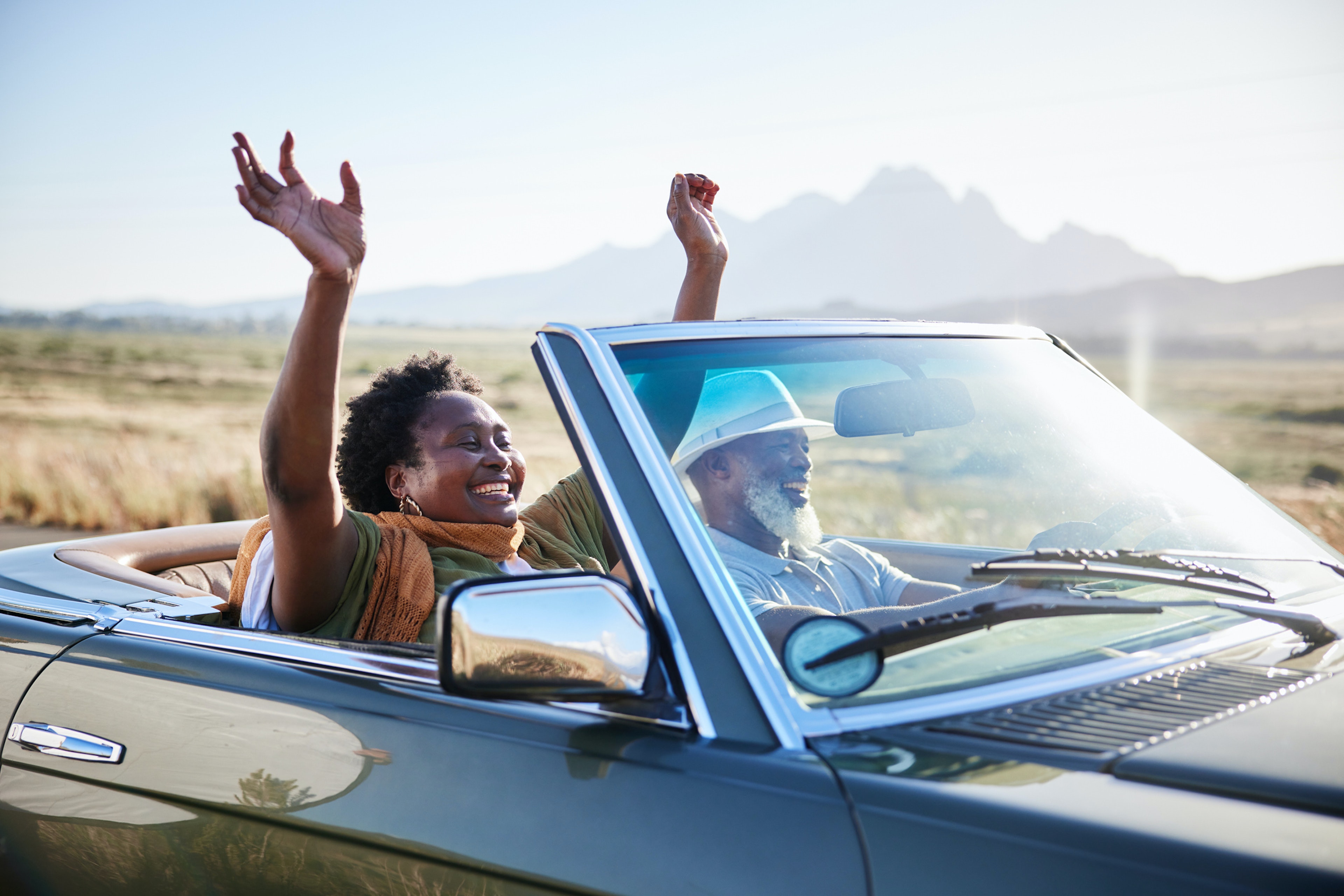 Mature African woman smiling with her hands raised in the air during a scenic road trip with her husband in their convertible
1387323834
Mature African woman smiling with her hands raised in the air during a scenic road trip with her husband in their convertible
