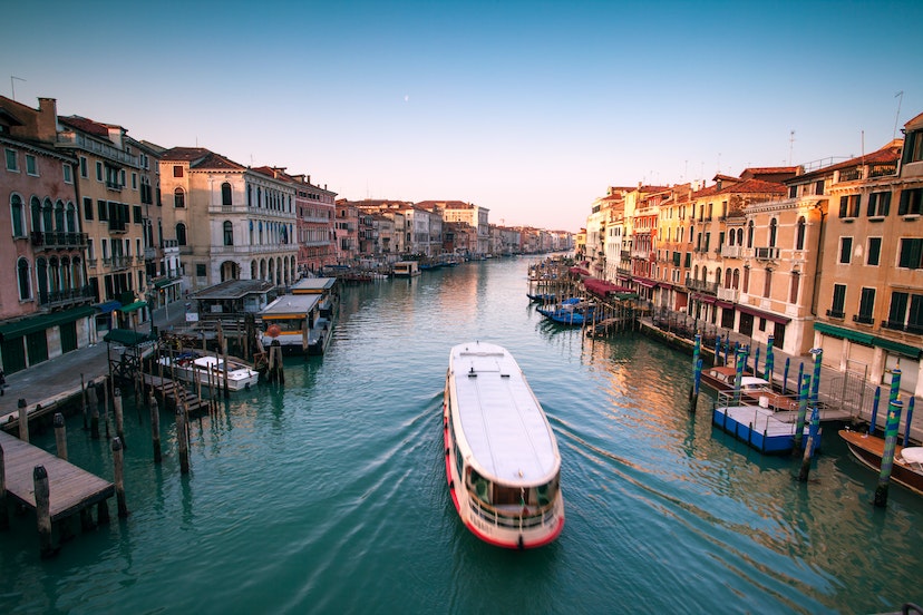 Vaporetto passing on Grand Canal, seen from Rialto bridge, at sunrise. Venice, Italy