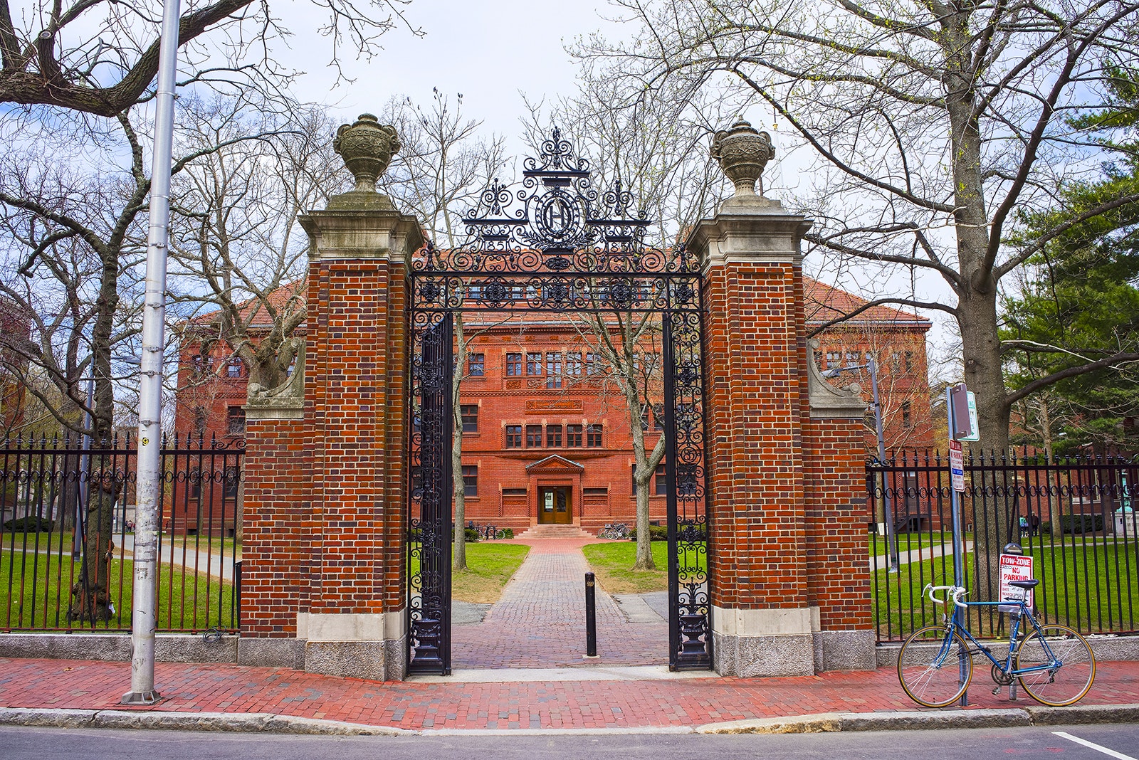 red brick gateposts and wrought iron, open gate leading to a redbrick residence hall at Harvard on a sunny day