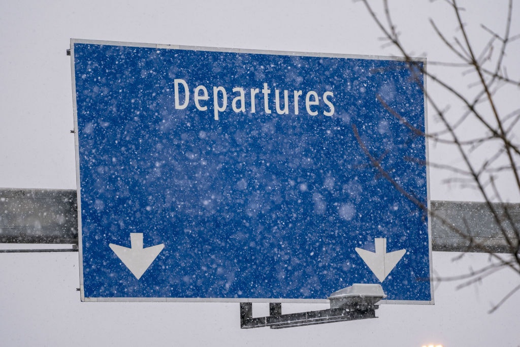 A "Departures" sign during a snow storm at Seattle-Tacoma International Airport (SEA) in Seattle, Washington, US, on Tuesday, Dec. 20, 2022. An estimated 112.7 million people will travel 50 miles or more from Dec. 23 to Jan. 2, up by 3.6 million from last